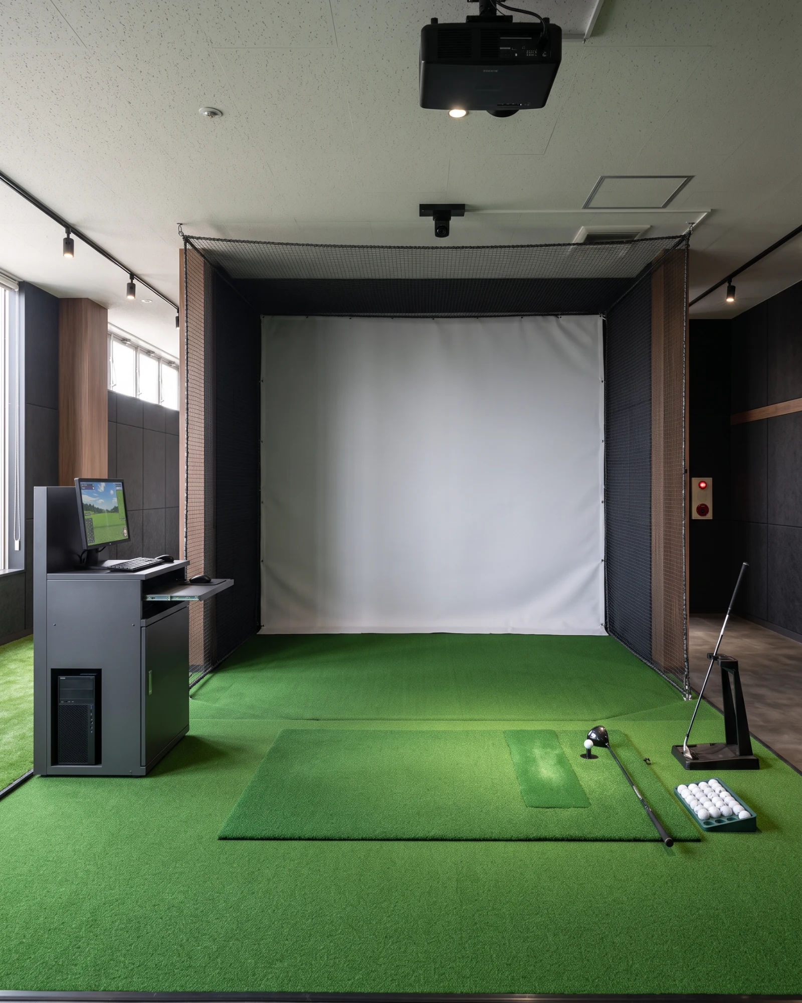 スクリーン、プロジェクター、打席、防球設備を備えたゴルフシミュレーター