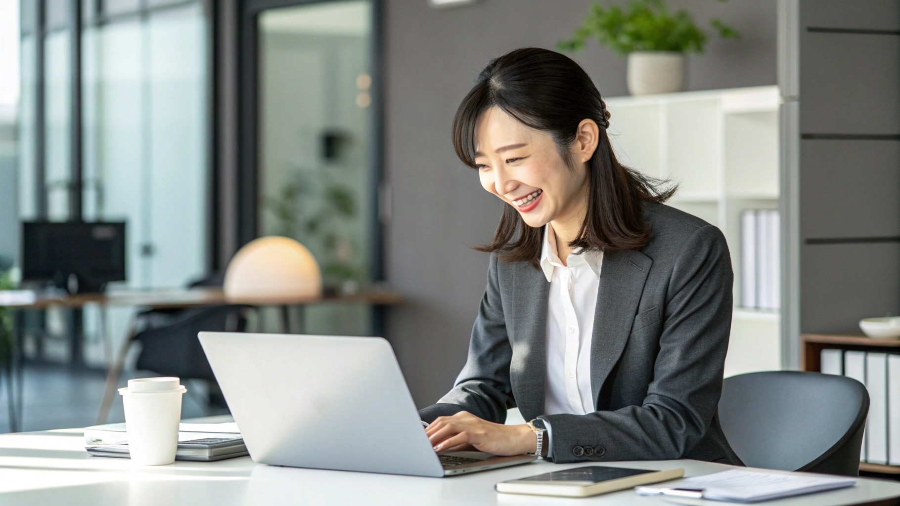 PCで作業する笑顔のビジネスウーマン